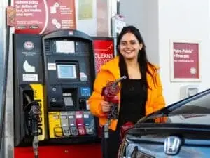 Happy customer filling up her car with gas