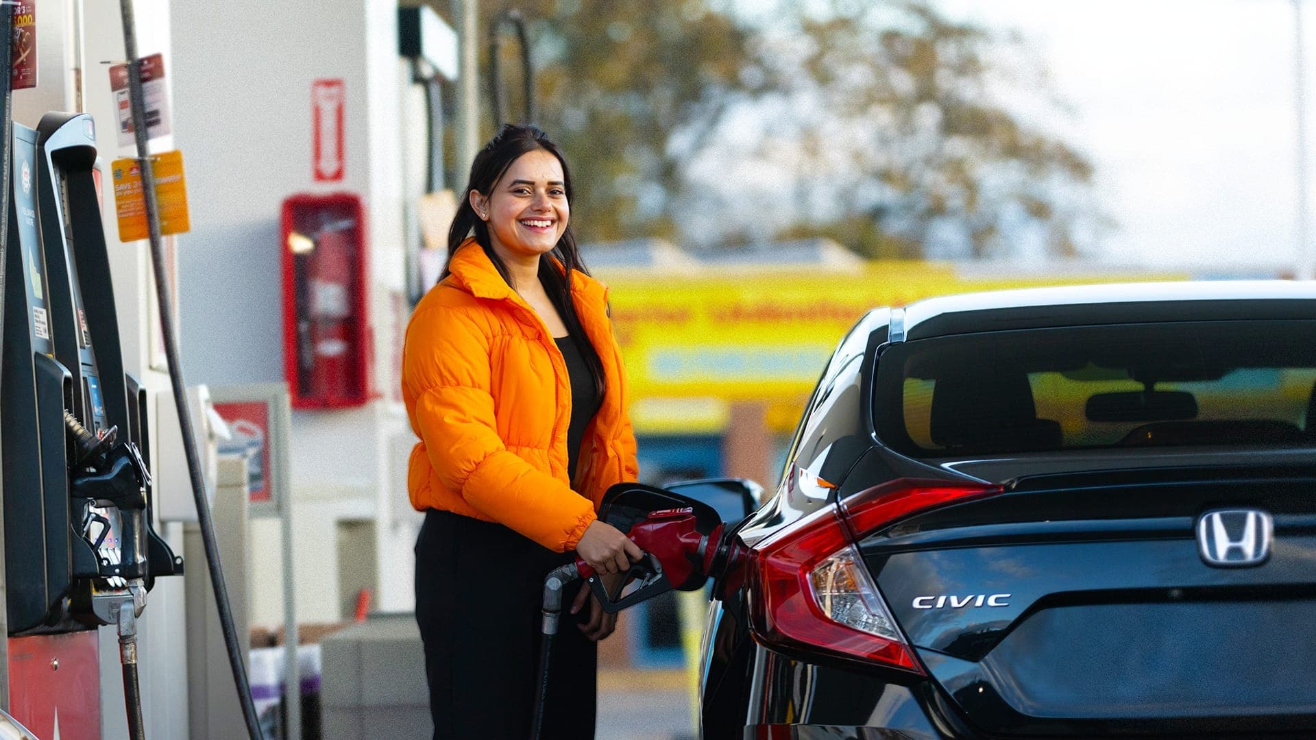 Happy customer filling up her car with gas