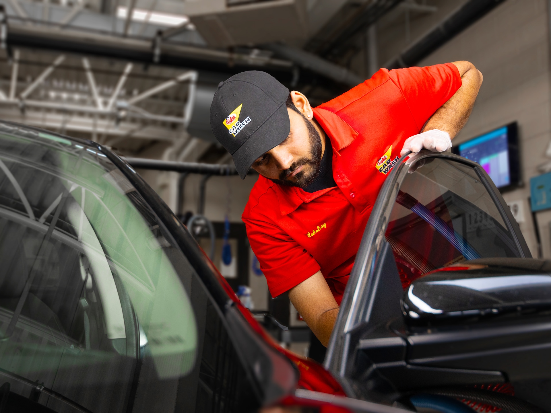 Valet technician cleaning a customer's car door