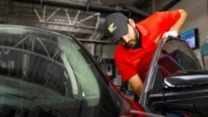 Valet technician cleaning a customer's car door