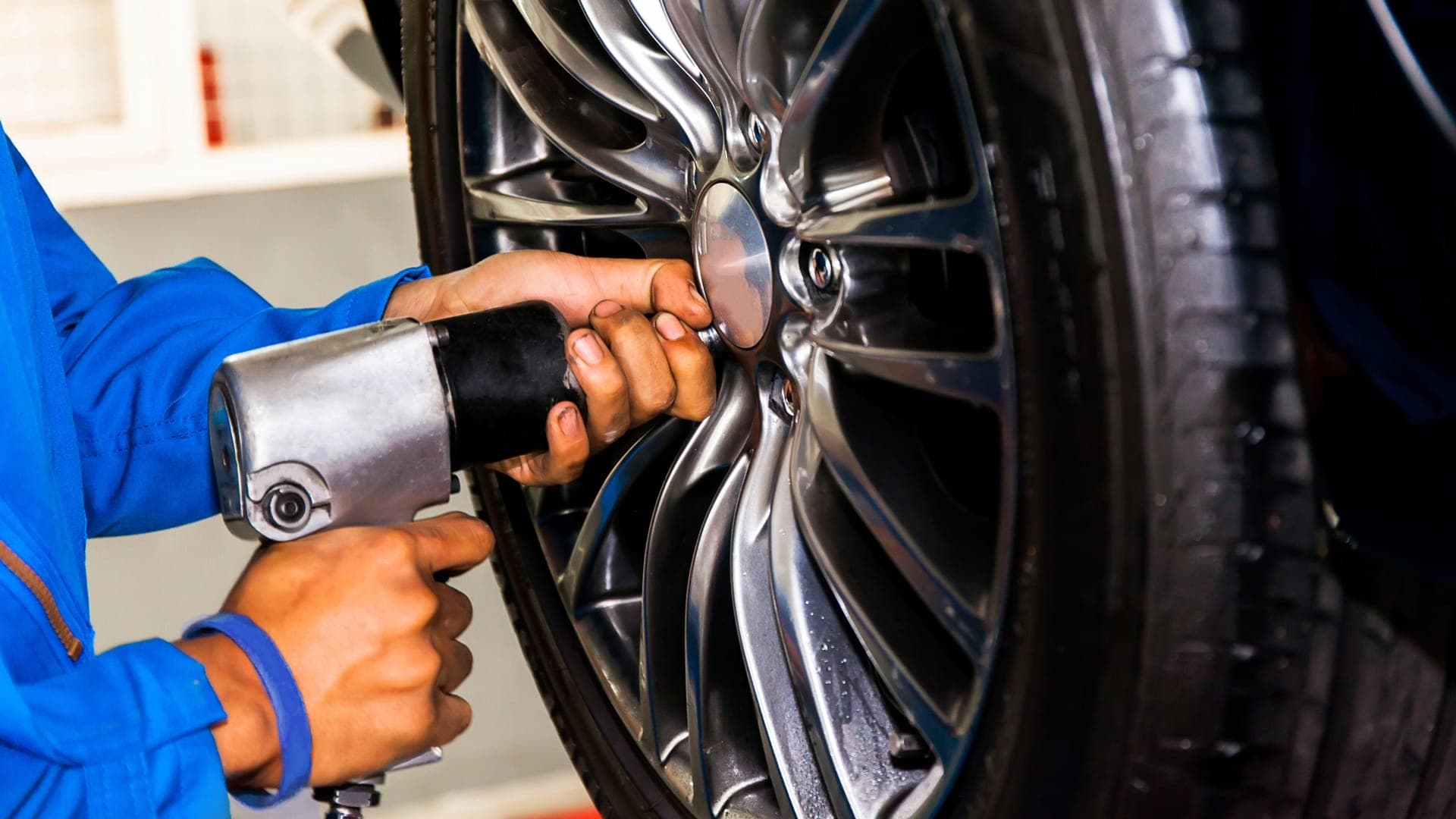 Valet technician unbolting car tire