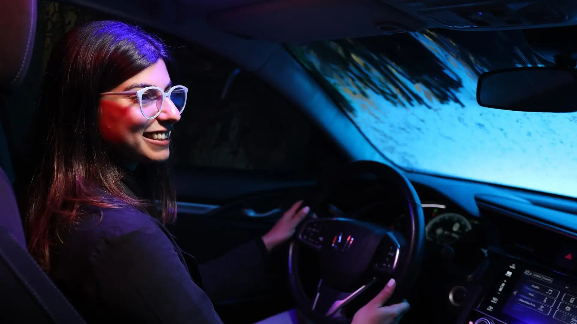 Happy customer inside their car in the middle of a car wash cycle