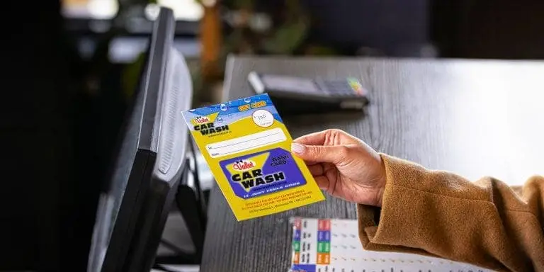 Person holding a Valet Car Wash gift card at checkout