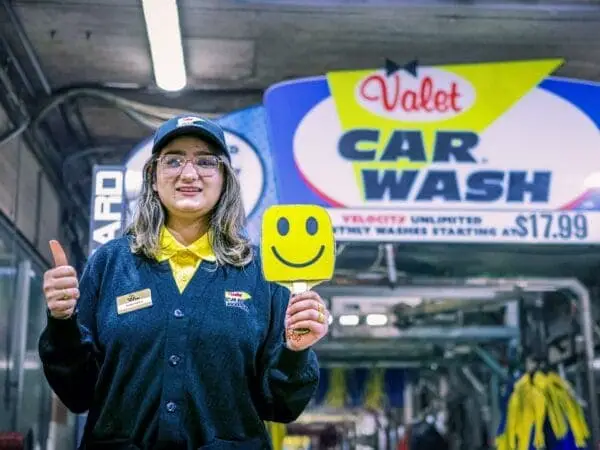 Picture of a Valet employee holding a sign with a smiley face